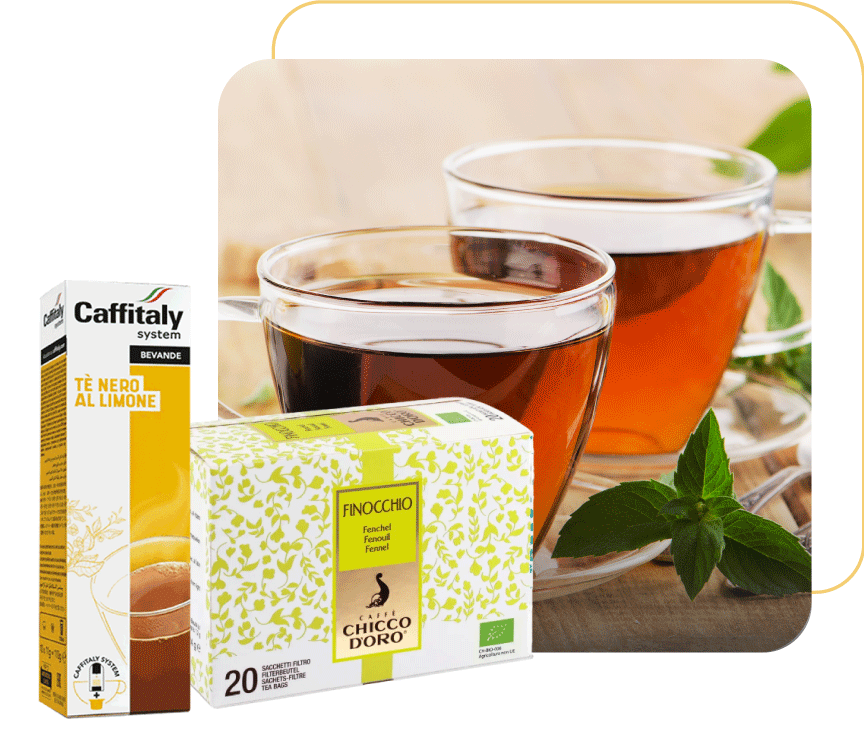 In primo piano due confezioni di prodotti Caffè Chicco D'oro, una confezione di Tè al finocchio in bustine e una confezione di Tè nero al limone in capsule Caffitaly, sullo sfondo due tazzine da Tè ripiene di tè.