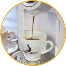 Una macchina a capsule chicco d'oro che eroga caffè in una tazzina caffè chicco d'oro